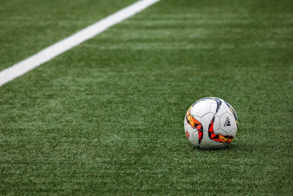 Ballon de foot sur un terrain de foot pour illustrer la gestion de patrimoine pour les footballers professionnels